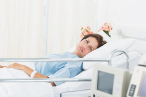 Female patient lying in medical bed at the hospital ward